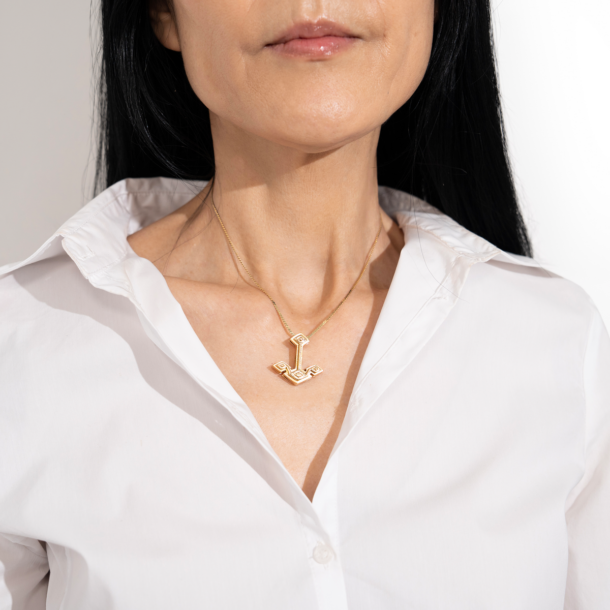 Woman wearing Root Anchor Pendant framed in open white button down shirt collar 